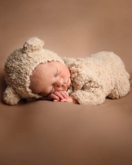 Ein schlafendes Baby in einem weichen, tierähnlichen Outfit.